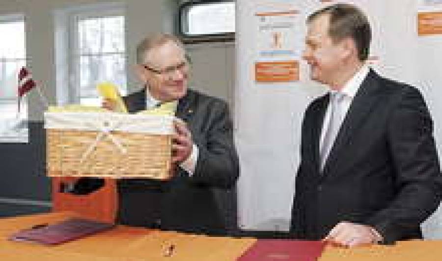 Глава Swedbank Марис Авотиньш (справа) вручил мэру Риги Янису Бирксу корзину с продовольствием.