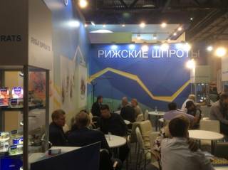 Продавцы шпрот пытаются на словах рассказать о вкусовых качествах консервов.