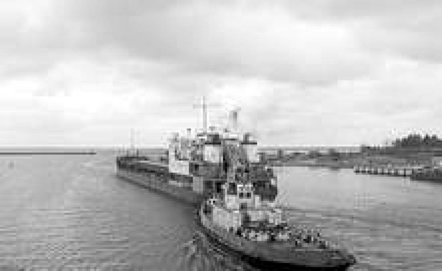 Лоцманский буксир заводит корабль в Тосмарский канал.