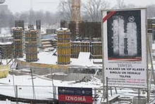 Стройплощадку медленно покрывает снег.